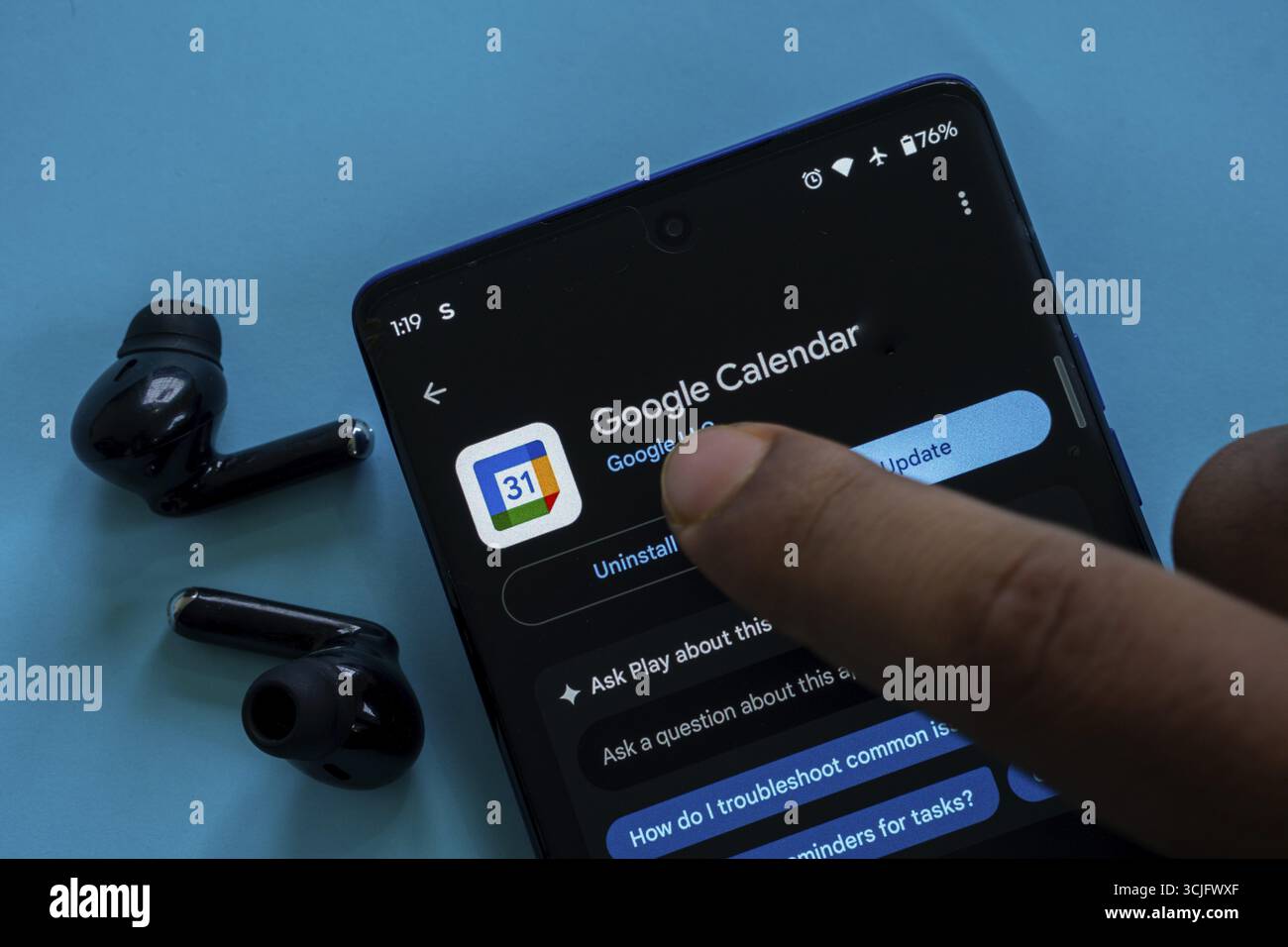 Der Finger des Benutzers zeigt auf dem Smartphone auf die Update-Option der Google Calendar App Stockfoto
