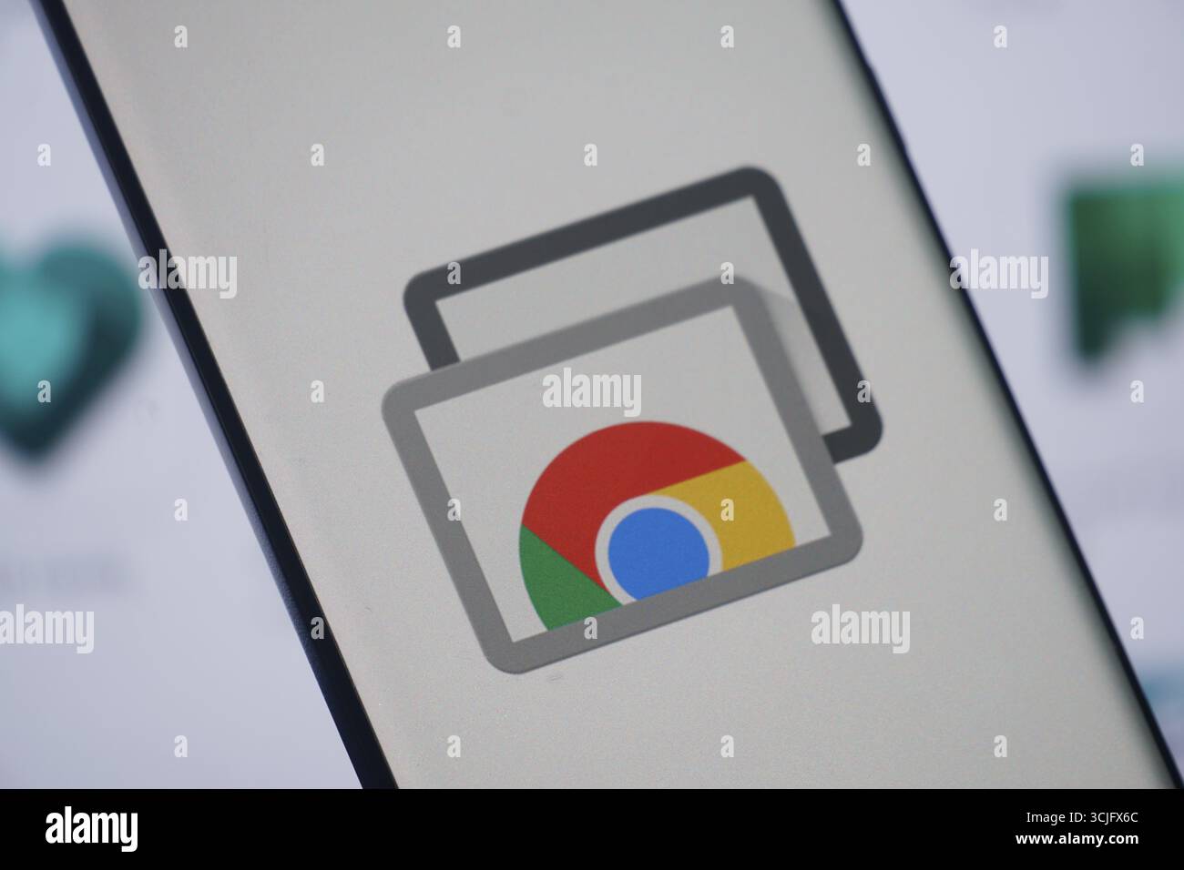Chrome Remote Desktop-Logo mit überlappenden Symbolen auf dem Laptop-Bildschirm Stockfoto