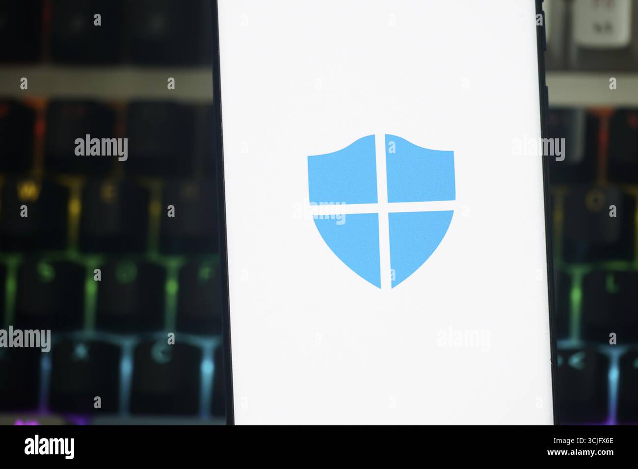 Ein Smartphone-Bildschirm, auf dem das Symbol der Microsoft Defender App auf weißem Hintergrund angezeigt wird und die digitale Sicherheit in einer technischen Umgebung symbolisiert Stockfoto