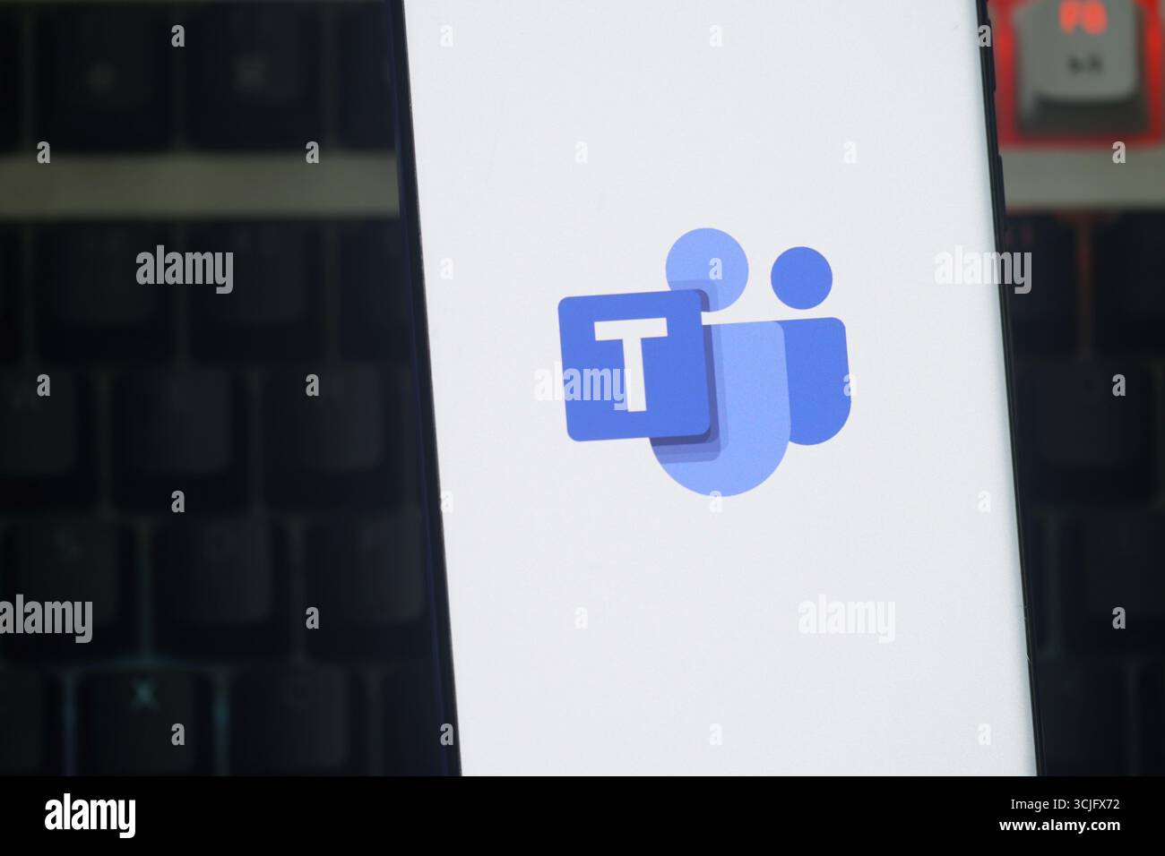 Das Microsoft Teams-Logo wird auf einem Smartphone-Bildschirm vor einem dunklen Tastaturhintergrund angezeigt Stockfoto