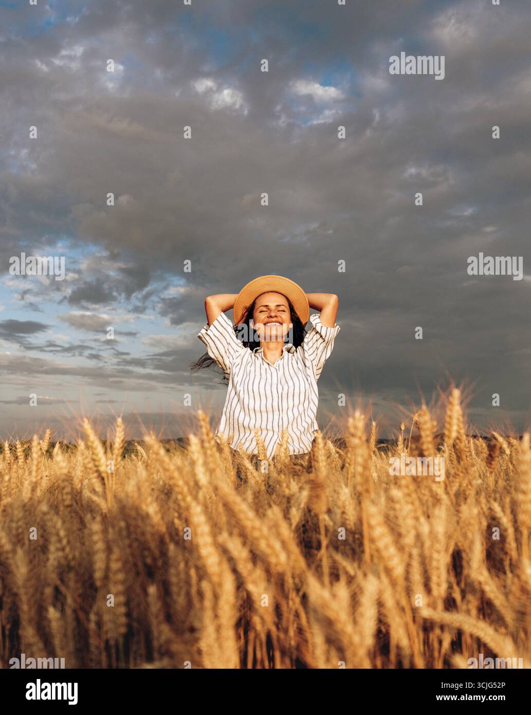 Frau im Weizenfeld genießt friedliche Momente in der Natur Stockfoto