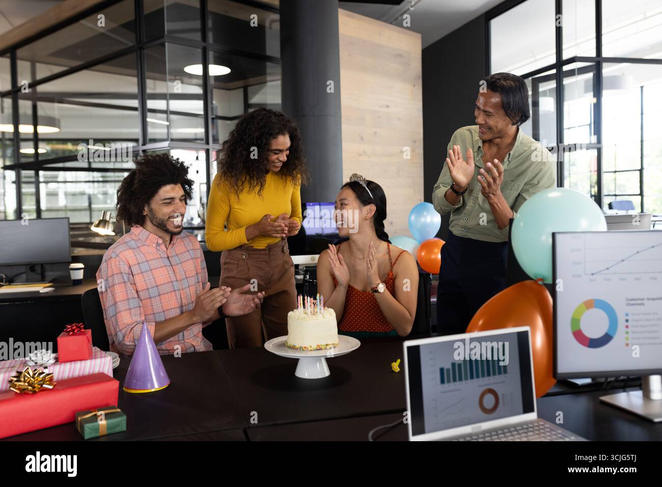 Wir feiern Geburtstag im Büro, verschiedene Kollegen klatschen um Kuchen und Ballons Stockfoto