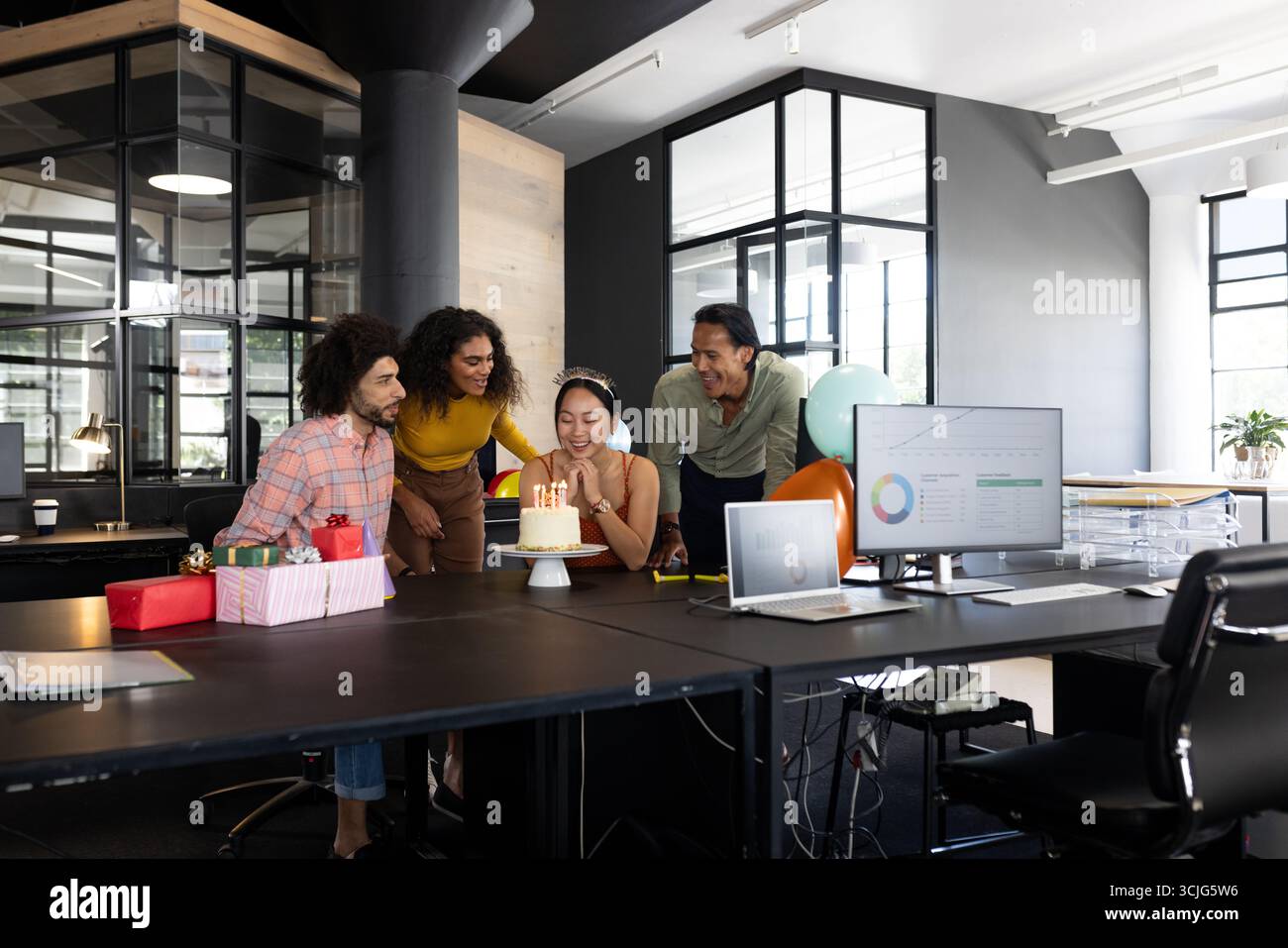 Kollegen feiern Geburtstag im modernen Büro mit Kuchen und Geschenken auf dem Schreibtisch Stockfoto