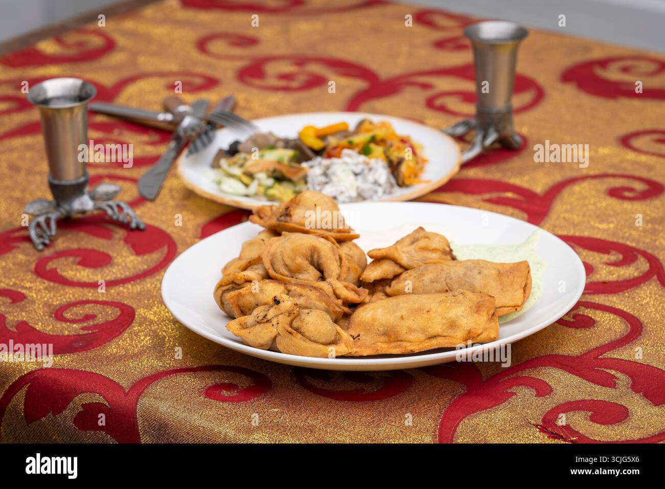 Gebratene Teigtaschen auf einem weißen Teller. Frittierte russische Teigtaschen (pelmeni). Traditionelle frittierte Pelmeni, Ravioli, Teigtaschen gefüllt mit Fleisch. Stockfoto