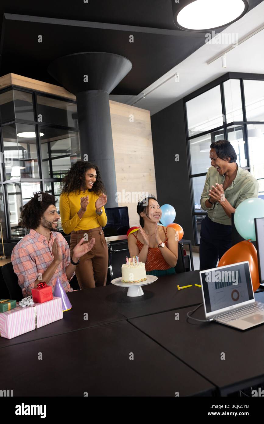 Geburtstag im Büro feiern, verschiedene Kollegen klatschen um Kuchen und Geschenke Stockfoto