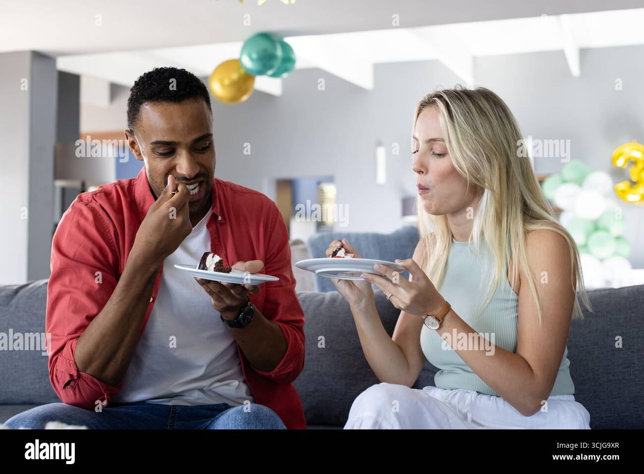 Gemeinsam Kuchen genießen, afroamerikanischer Mann und Frau zu Hause feiern Stockfoto