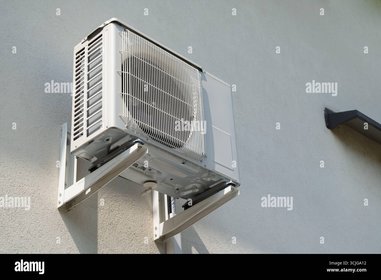 Außeneinheit einer geteilten Klimaanlage, die an der Außenwand eines Gebäudes zur Kühlung des Raumklimas in warmen Ländern für hlk montiert ist Stockfoto