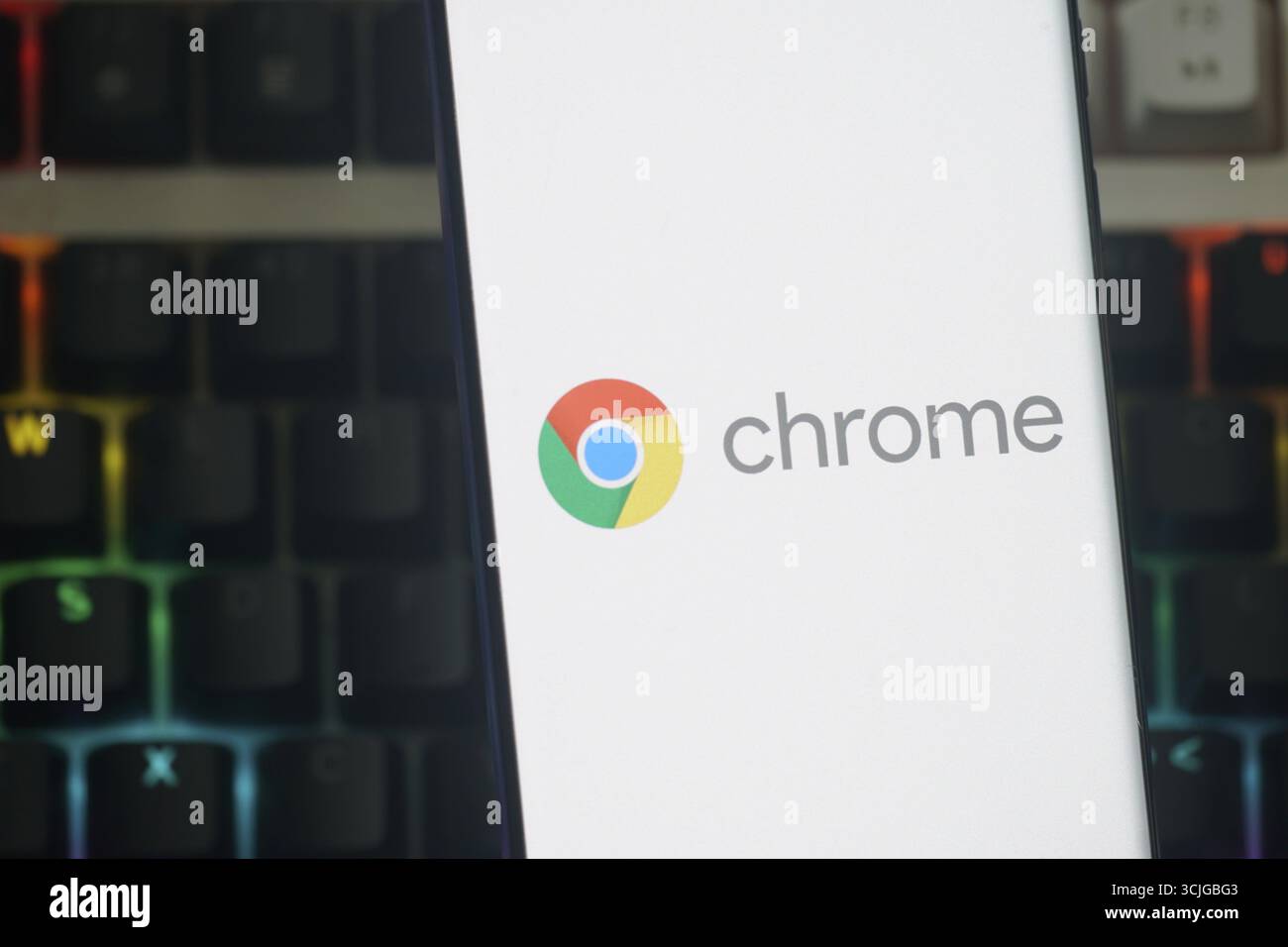 Google Chrome-Logo wird auf einem Smartphone-Bildschirm mit beleuchtetem Tastaturhintergrund angezeigt Stockfoto
