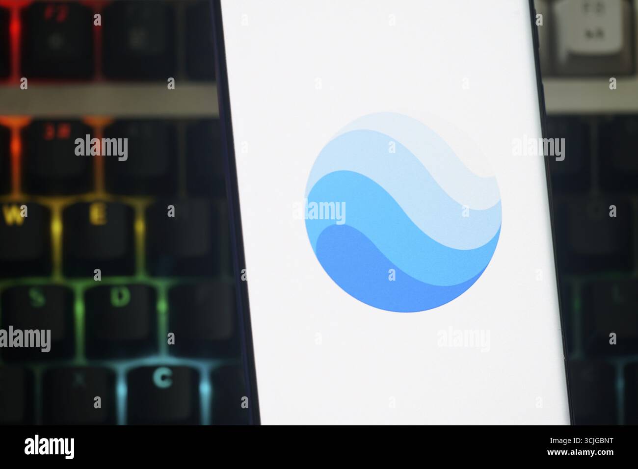 Google Earth Logo in Blau mit Wellendesign auf einem Smartphone-Bildschirm Stockfoto