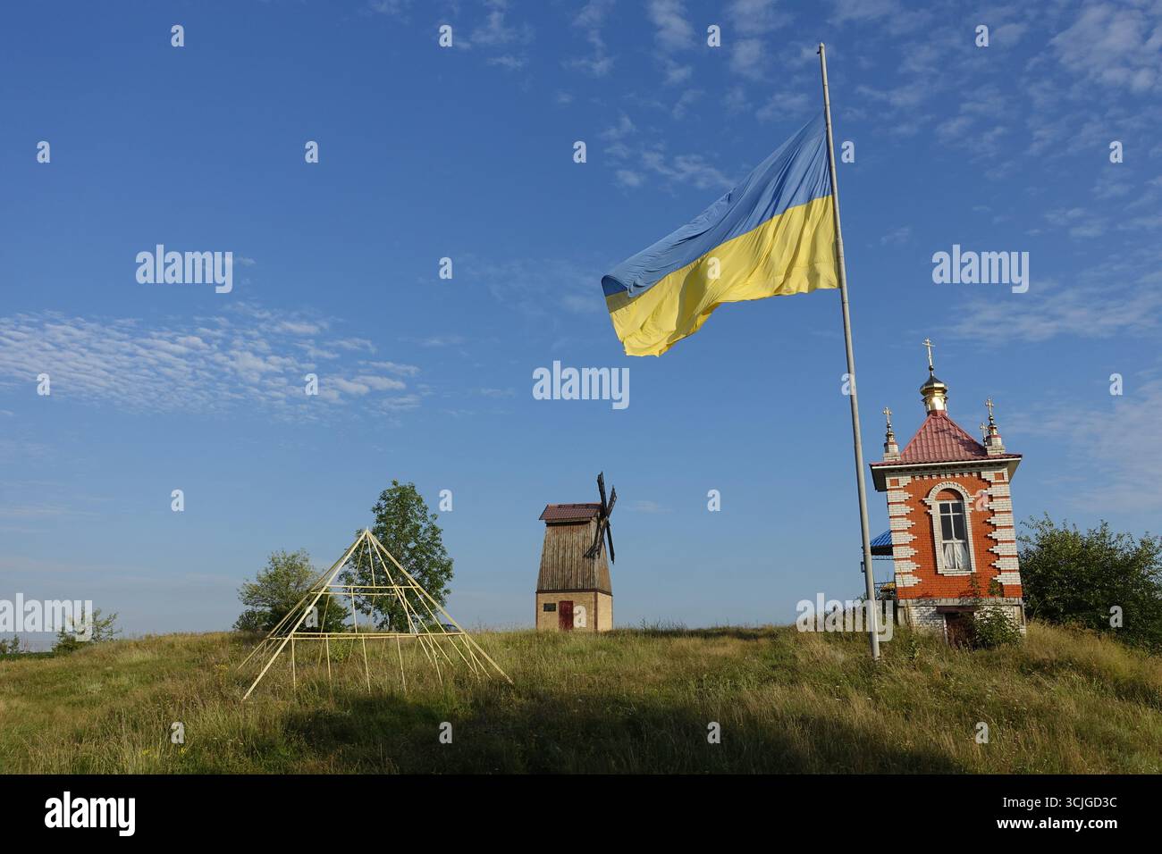 Eine ukrainische Flagge und eine Mühle auf einem Hügel in der Nähe von Kiew Kiew Stockfoto