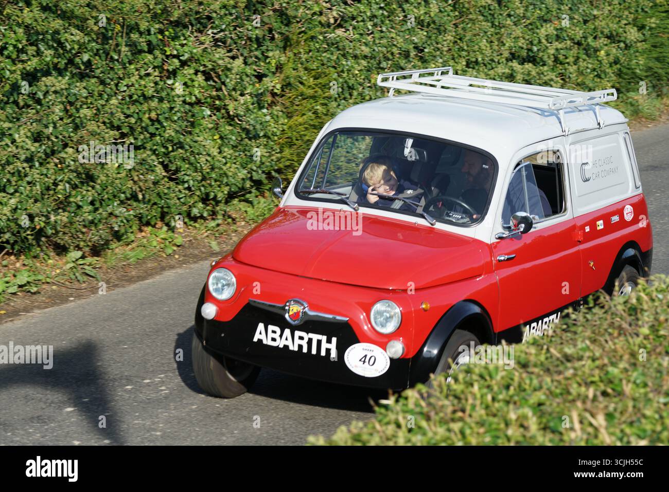 Klassisches Retro Red Abarth Auto, das auf einer Landstraße fährt. Shere Hill Climb, East Clandon, Guildford Stockfoto
