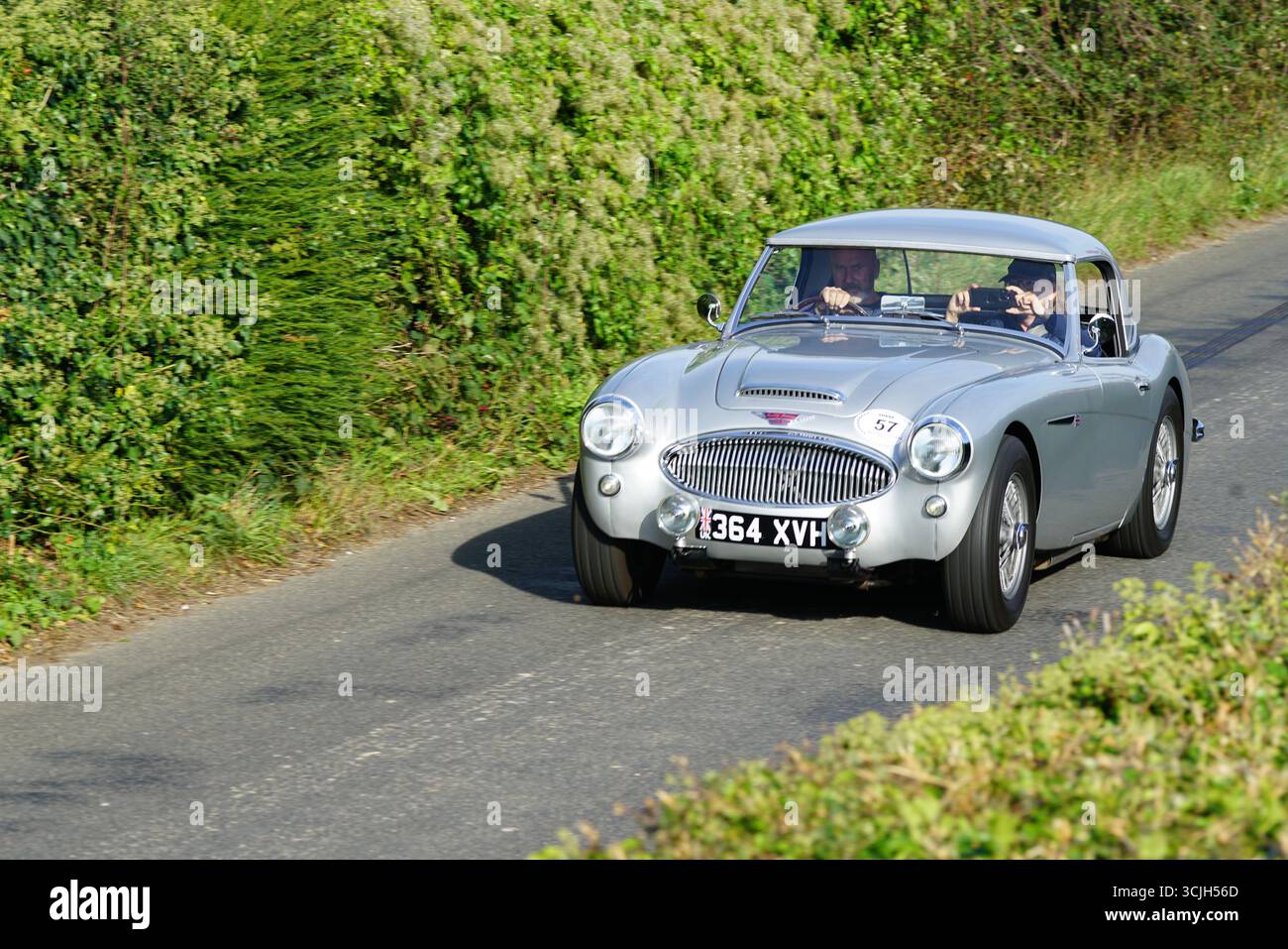 Klassischer Silver Sports Car, der bei Tageslicht auf einer landschaftlich reizvollen Landstraße fährt. Shere Hill Climb, East Clandon, Guildford Stockfoto