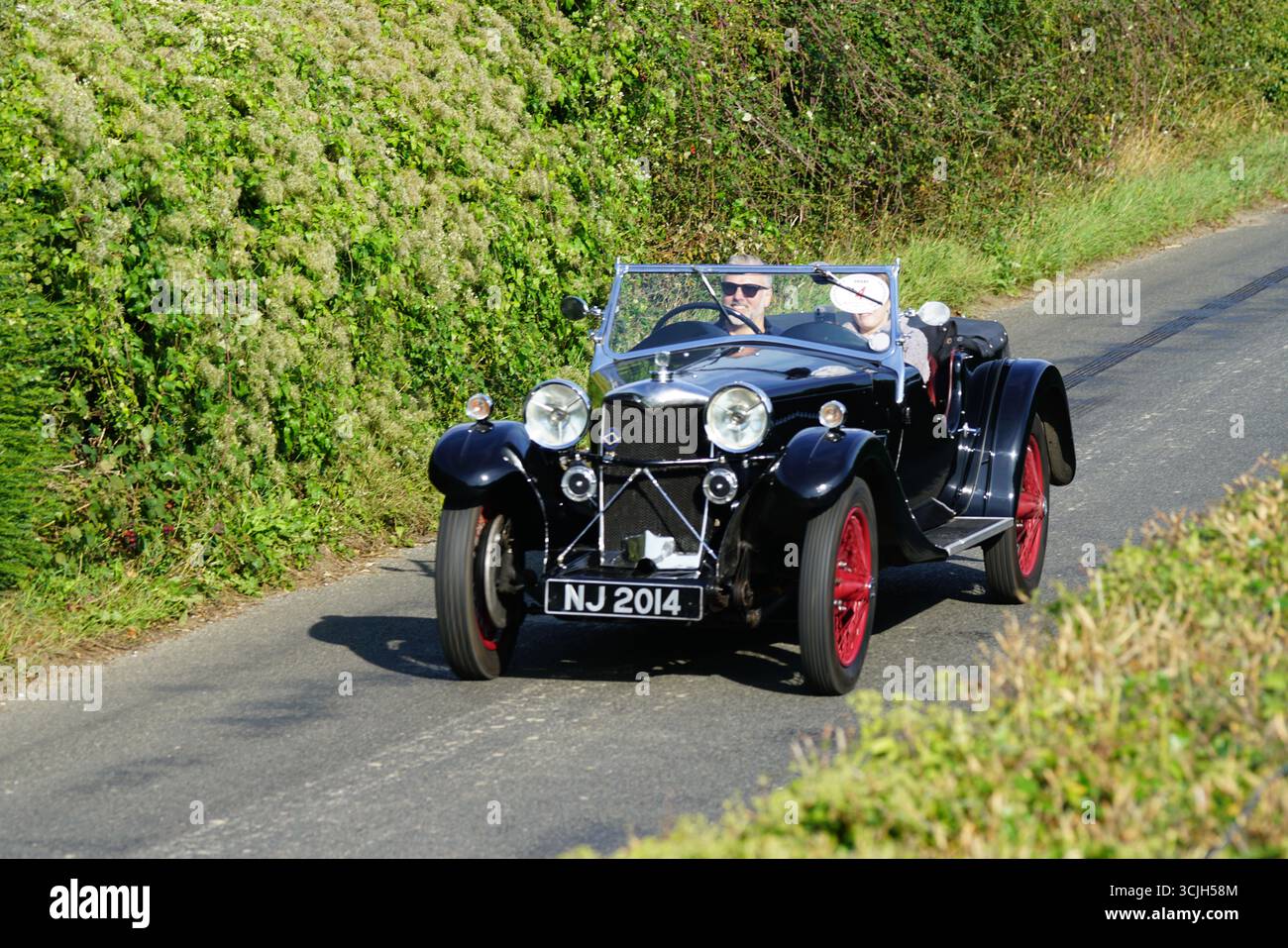 Oldtimer-Cabriolet, Das Während Des Sonnentages Durch Die Landstraße Fährt. Shere Hill Climb, East Clandon, Guildford Stockfoto