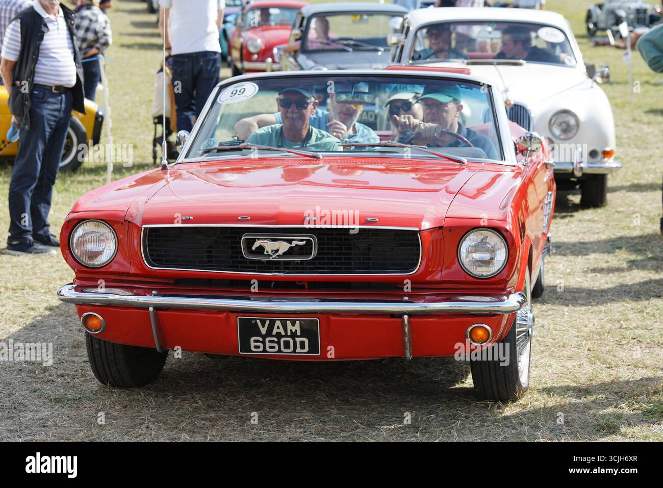 Klassischer roter Mustang mit Leuten bei einem Outdoor Car Event. Shere Hill Climb, East Clandon, Guildford Stockfoto