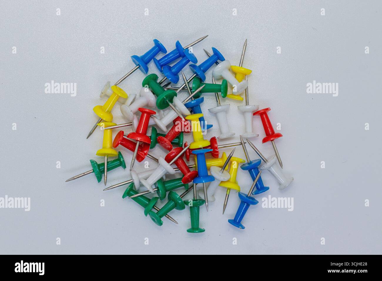 Mehrfarbige Daumentaster für Büro und Schule auf isoliertem weißem Hintergrund. Stockfoto