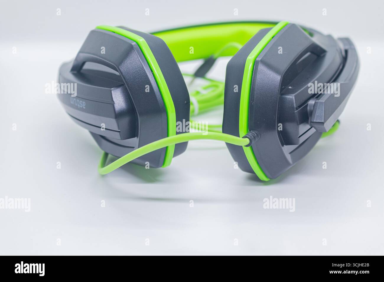 Gaming-Headset in Schwarz und Grün mit kabelgebundener Verbindung auf weißem Studio-Hintergrund. Stockfoto