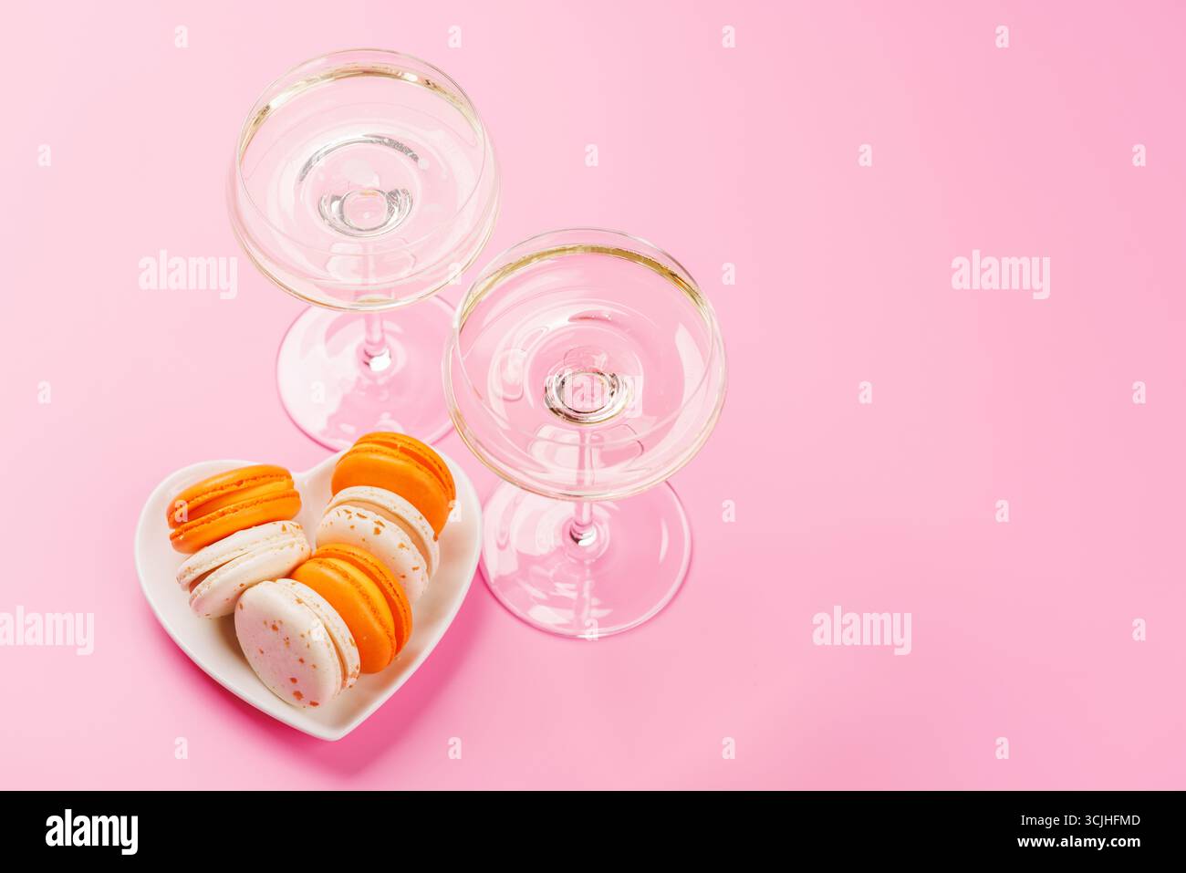 Eine luxuriöse Kombination aus Champagner und zarten Makronen, die eine elegante und verwöhnende Gaumenfreude schaffen. Perfekt für Feiern, besondere Anlässe und gou Stockfoto