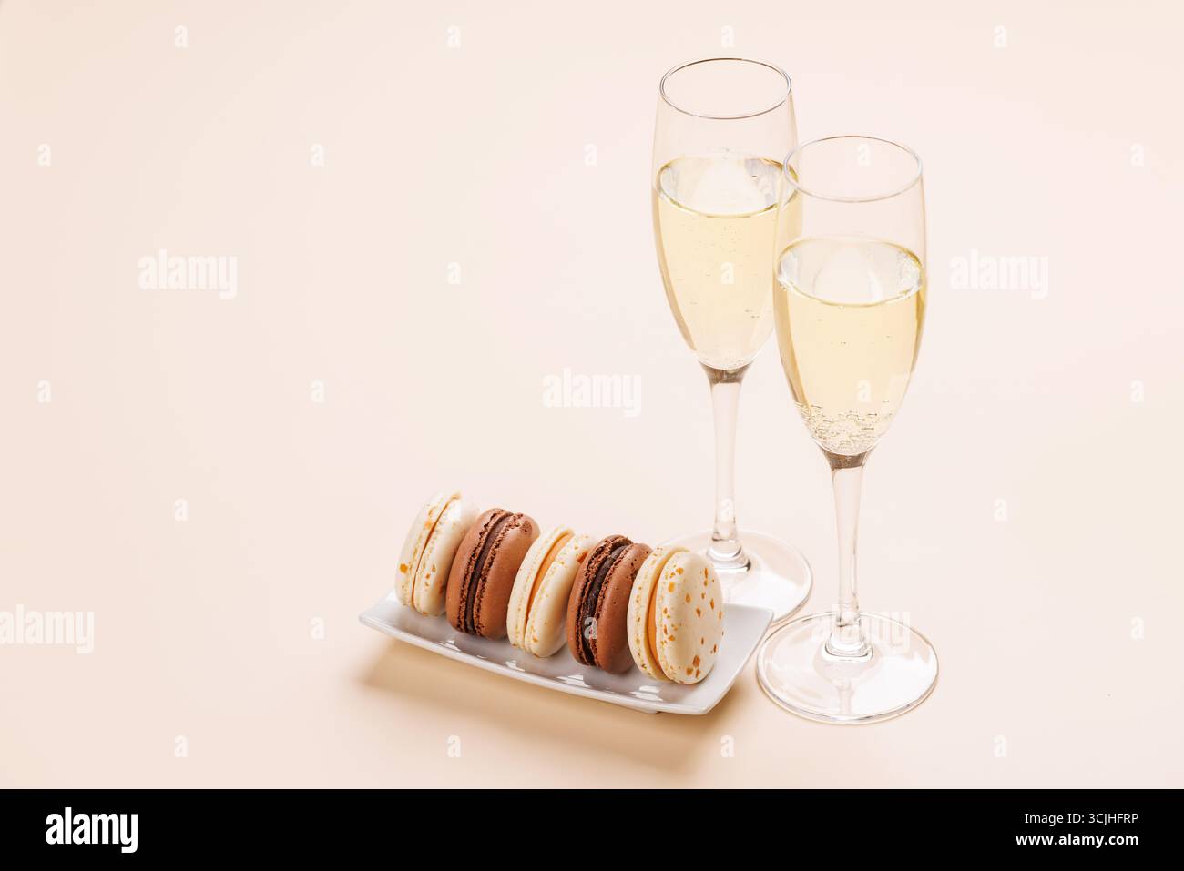 Eine luxuriöse Kombination aus Champagner und zarten Makronen, die eine elegante und verwöhnende Gaumenfreude schaffen. Perfekt für Feiern, besondere Anlässe und gou Stockfoto