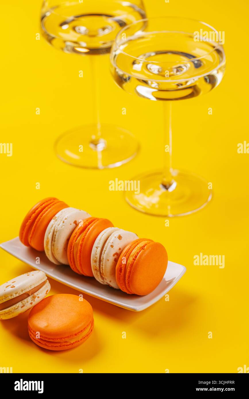 Eine luxuriöse Kombination aus Champagner und zarten Makronen, die eine elegante und verwöhnende Gaumenfreude schaffen. Perfekt für Feiern, besondere Anlässe und gou Stockfoto