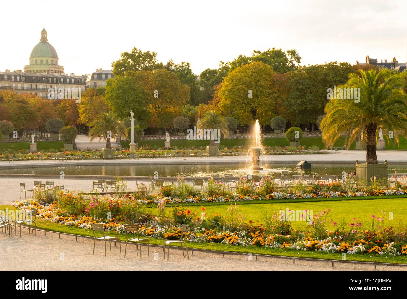 Ein Brunnen, der von der frühen Sonne erleuchtet wird und von Sommergrenzen umgeben ist, im Jardin du Luxembourg. Stockfoto