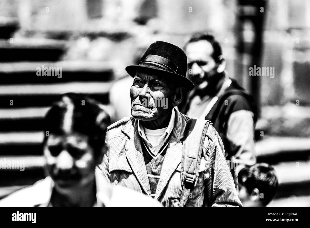 Quito, Ecuador – 23. März 2018: Ehrliche Schwarzweiß-Porträts älterer ecuadorianischer Männer, die im historischen Zentrum von Quito spazieren Stockfoto
