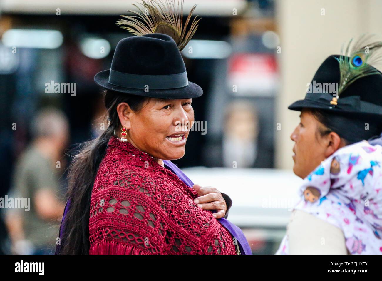 Quito, Ecuador – 23. März 2018: Zwei indigene Kichwa-Frauen in traditioneller Andenkleidung, darunter schwarze Filzhüte mit Federn Stockfoto