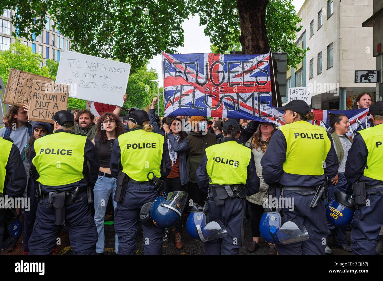 Bristol, Großbritannien. September 2025. Anti-Rassismus-Aktivisten werden vor dem Hampton by Hilton Hotel im Zentrum von Bristol abgebildet, während sie an einem Gegenprotest gegen Anti-Einwanderungs-Demonstranten teilnehmen, die gegen illegale Einwanderer protestierten, die nach Großbritannien einreisen. Der Protest gegen die Einwanderung wurde von einer Gruppe namens "Bristol Patriots" organisiert. Die Polizei in Bristol hat zusätzliche Befugnisse erhalten, um Menschen aufzuhalten und zu zerstreuen, um zu verhindern, dass Probleme zwischen der rechtsextremen Gruppe und den antirassistischen Demonstranten entstehen. Quelle: Lynchpics/Alamy Live News Stockfoto