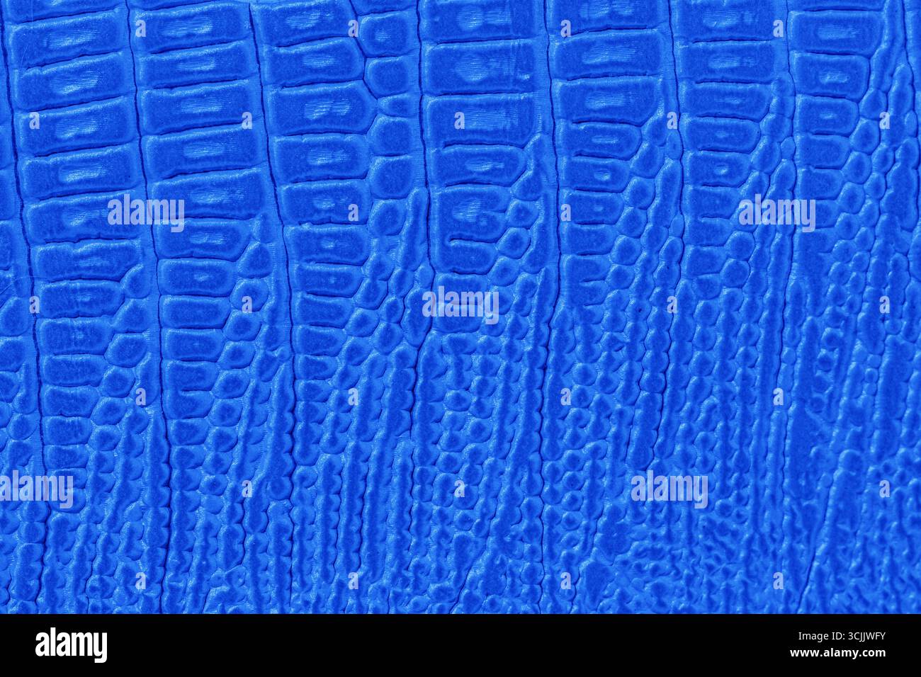 Leuchtendes Blau mit Reptilienimitat, tiefem Schuppen und glänzender Oberfläche. Konzept von exotischer Eleganz, futuristischer Mode, herausragender Textur Stockfoto