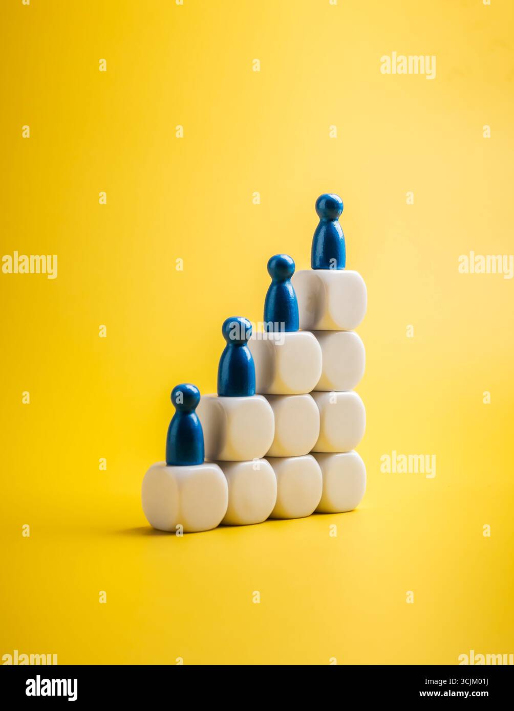 Bevölkerungswachstum und Technologieentwicklungskonzept mit blauen Holzfiguren auf weißen Stufenblöcken, die menschlichen Fortschritt, Innovation, soziale Evo symbolisieren Stockfoto