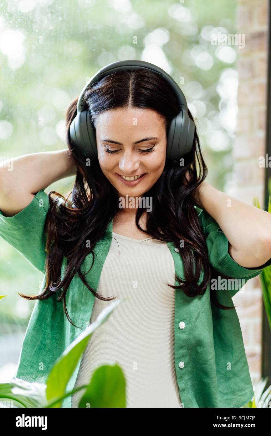 Entspannte Frau, die Freizeit genießt und Musik hört. Stockfoto