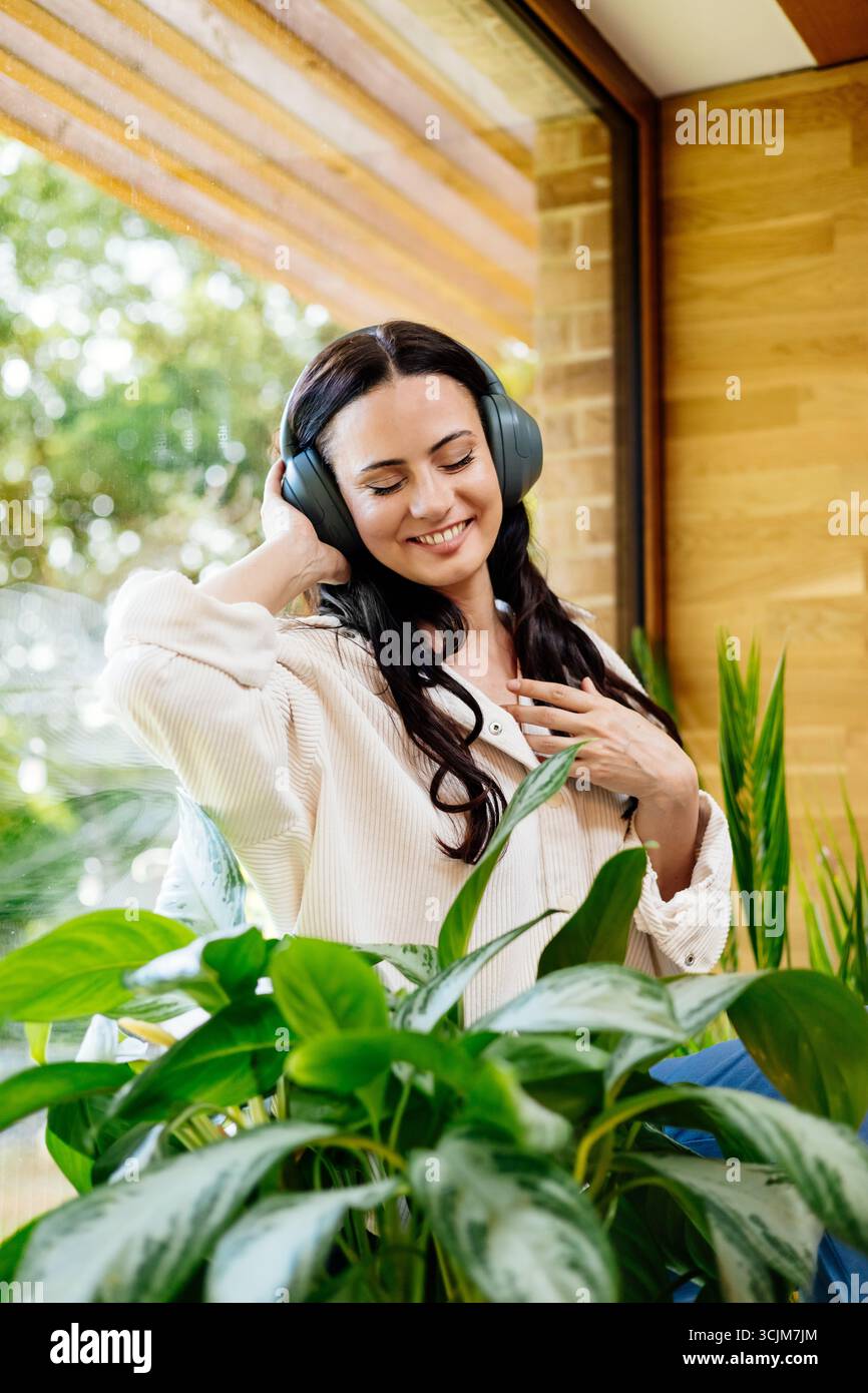 Entspannte Frau, die Freizeit genießt und Musik hört. Stockfoto