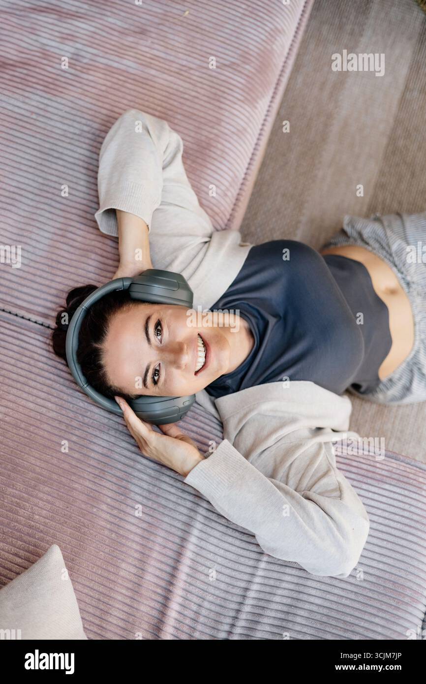 Frau, die sich zu Hause entspannt, Musik nach der Arbeit genießt. Stockfoto