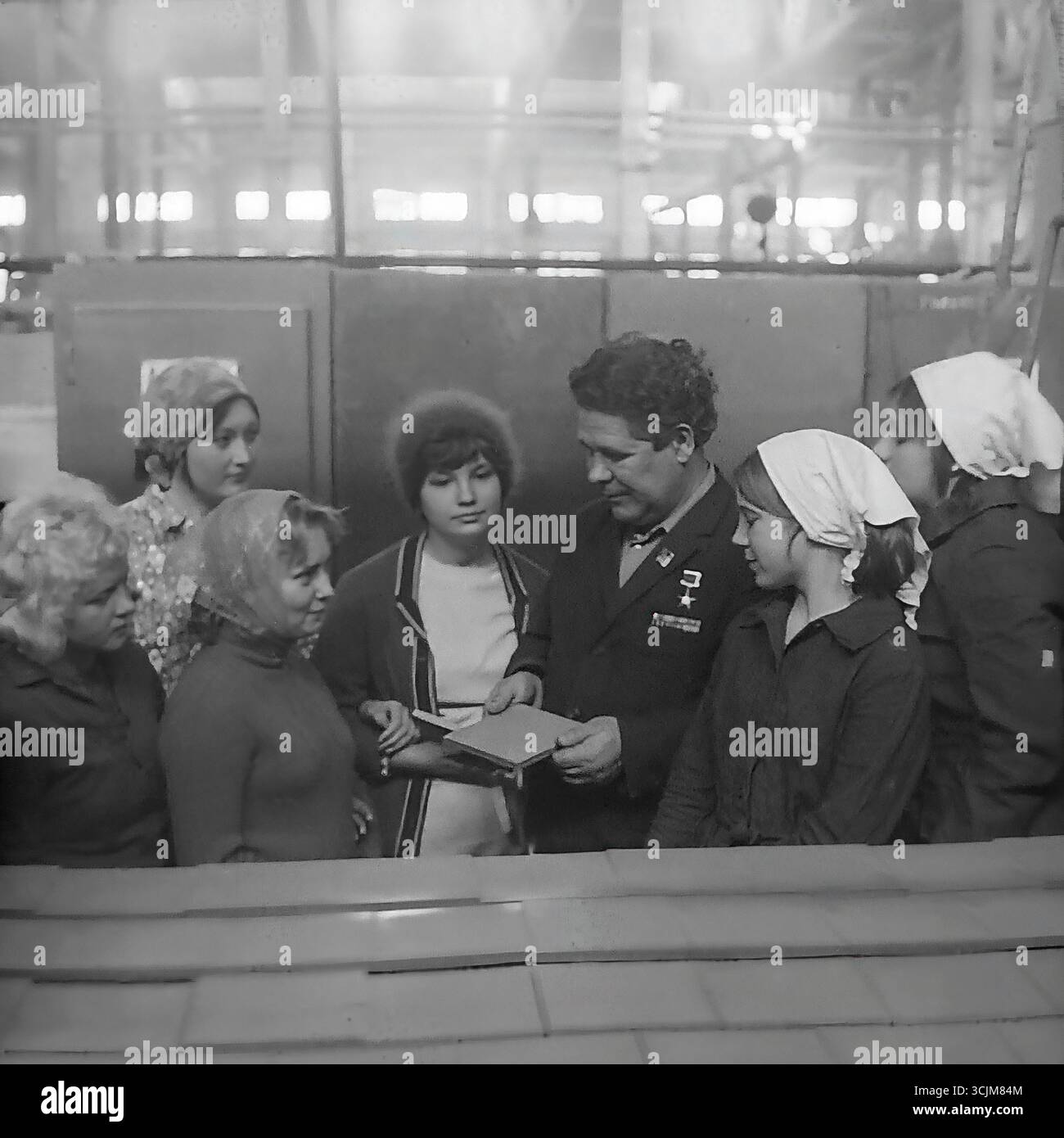 Ein Treffen eines Helden der Sozialistischen Arbeit mit einer Brigade junger Arbeiterinnen in einer Fabrik in Slawjansk, 1976. Diese Archivreportage, die eine Szene der Mentorschaft während der Stagnation-Ära aufzeichnet, ist ein Symbol für Generationenkontinuität, den Transfer von Berufserfahrung und die kreative Kultur eines friedlichen Donbas Stockfoto