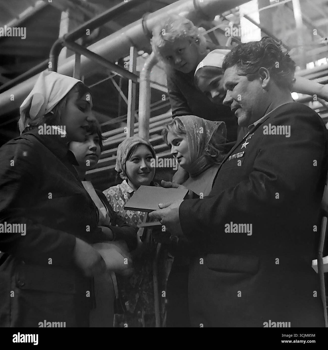 Ein Treffen eines Helden der Sozialistischen Arbeit mit einer Brigade junger Arbeiterinnen in einer Fabrik in Slawjansk, 1976. Diese Archivreportage, die eine Szene der Mentorschaft während der Stagnation-Ära aufzeichnet, ist ein Symbol für Generationenkontinuität, den Transfer von Berufserfahrung und die kreative Kultur eines friedlichen Donbas Stockfoto