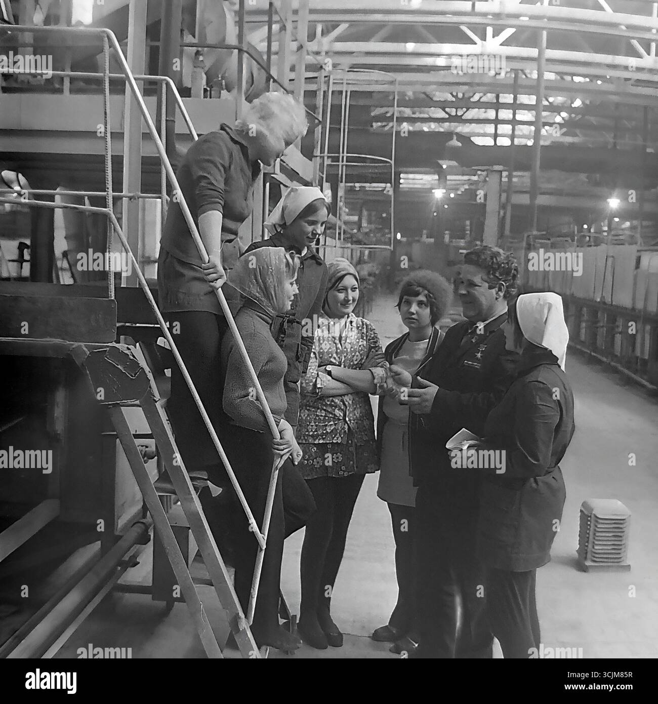 Ein Treffen eines Helden der Sozialistischen Arbeit mit einer Brigade junger Arbeiterinnen in einer Fabrik in Slawjansk, 1976. Diese Archivreportage, die eine Szene der Mentorschaft während der Stagnation-Ära aufzeichnet, ist ein Symbol für Generationenkontinuität, den Transfer von Berufserfahrung und die kreative Kultur eines friedlichen Donbas Stockfoto
