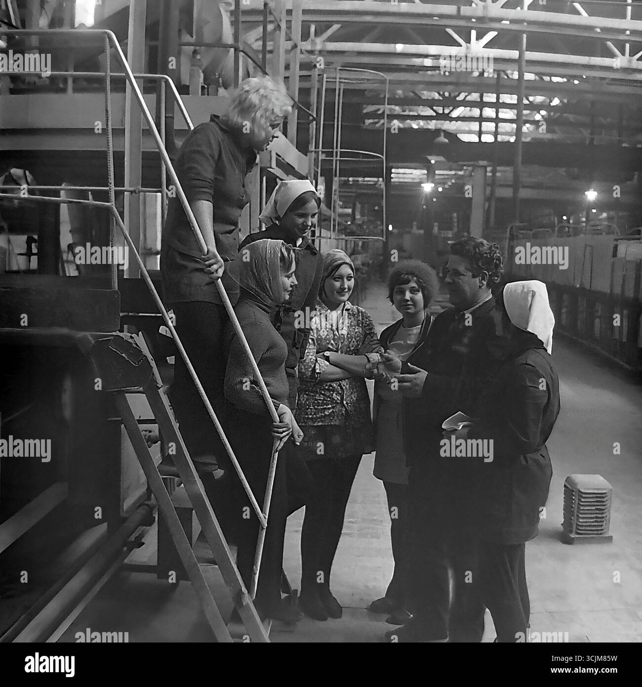Ein Treffen eines Helden der Sozialistischen Arbeit mit einer Brigade junger Arbeiterinnen in einer Fabrik in Slawjansk, 1976. Diese Archivreportage, die eine Szene der Mentorschaft während der Stagnation-Ära aufzeichnet, ist ein Symbol für Generationenkontinuität, den Transfer von Berufserfahrung und die kreative Kultur eines friedlichen Donbas Stockfoto