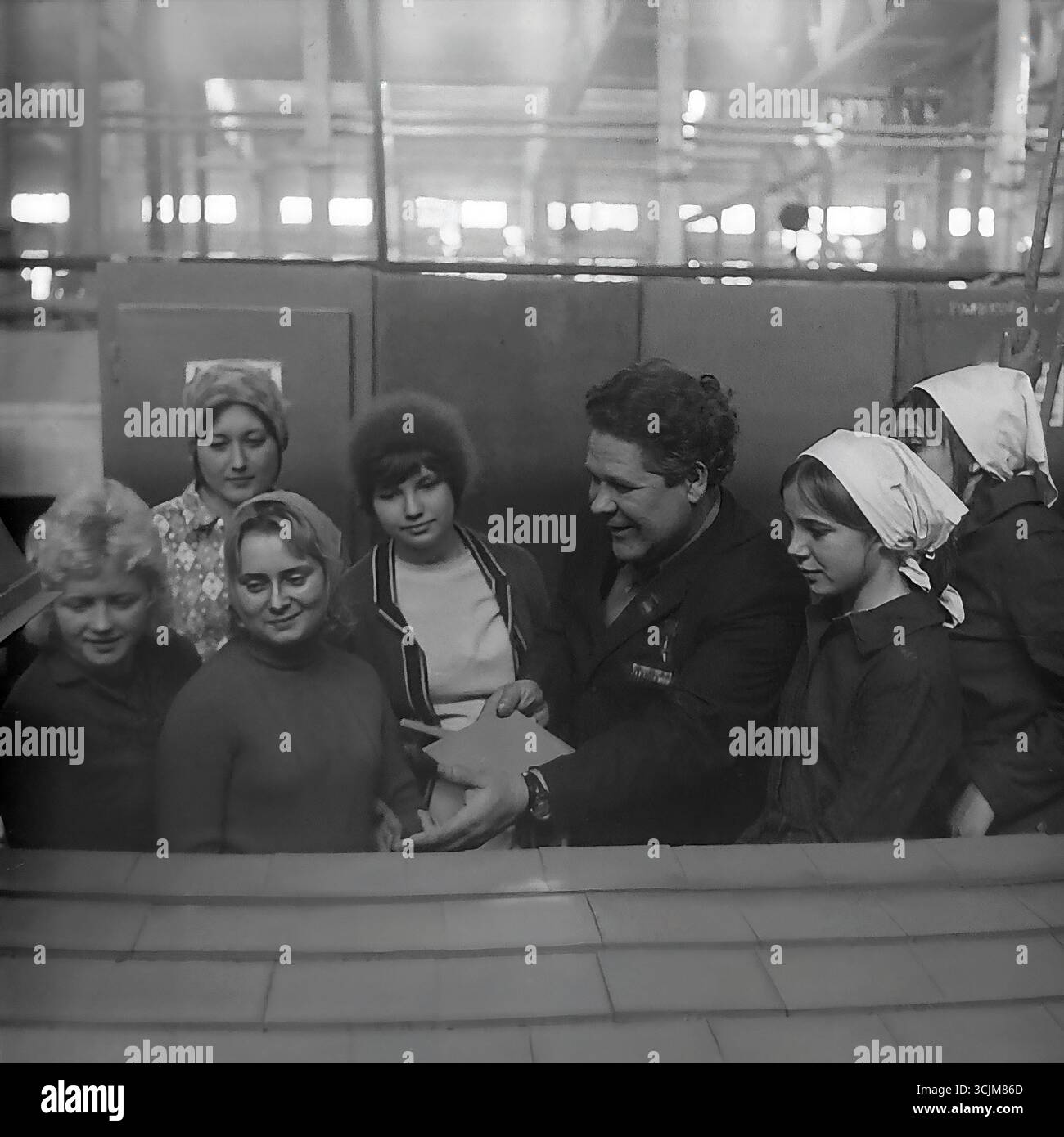 Ein Treffen eines Helden der Sozialistischen Arbeit mit einer Brigade junger Arbeiterinnen in einer Fabrik in Slawjansk, 1976. Diese Archivreportage, die eine Szene der Mentorschaft während der Stagnation-Ära aufzeichnet, ist ein Symbol für Generationenkontinuität, den Transfer von Berufserfahrung und die kreative Kultur eines friedlichen Donbas Stockfoto