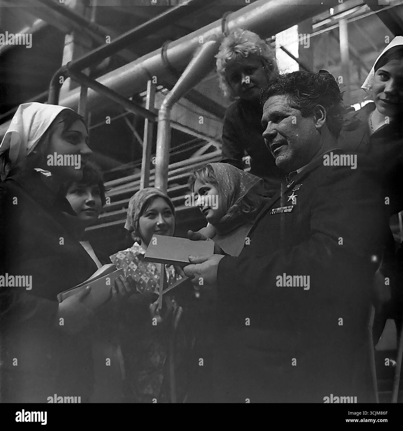 Ein Treffen eines Helden der Sozialistischen Arbeit mit einer Brigade junger Arbeiterinnen in einer Fabrik in Slawjansk, 1976. Diese Archivreportage, die eine Szene der Mentorschaft während der Stagnation-Ära aufzeichnet, ist ein Symbol für Generationenkontinuität, den Transfer von Berufserfahrung und die kreative Kultur eines friedlichen Donbas Stockfoto