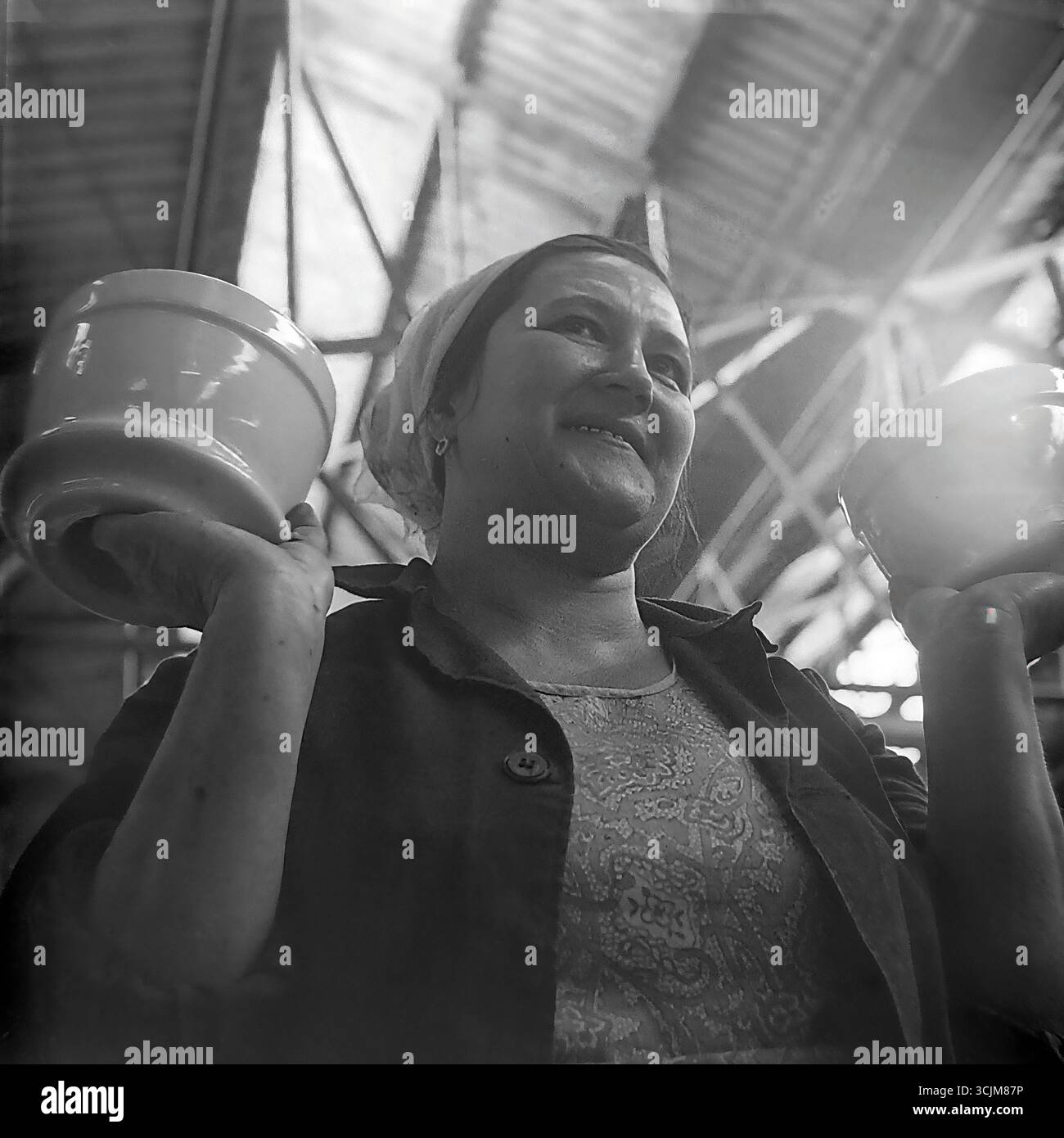 Ein heldenhaftes Porträt einer Arbeiterin der Keramikfabrik Slawjansk, die stolz Fertigprodukte zeigt, 1976. Diese monumentale Aufnahme im Stil des sozialistischen Realismus, die in einer Werkstatt der Stagnation-Ära aufgenommen wurde, ist ein Symbol für die Verherrlichung der arbeitenden Person, den „Fünfjahresplan der Qualität“ und die kreative Kraft eines friedlichen Donbas Stockfoto