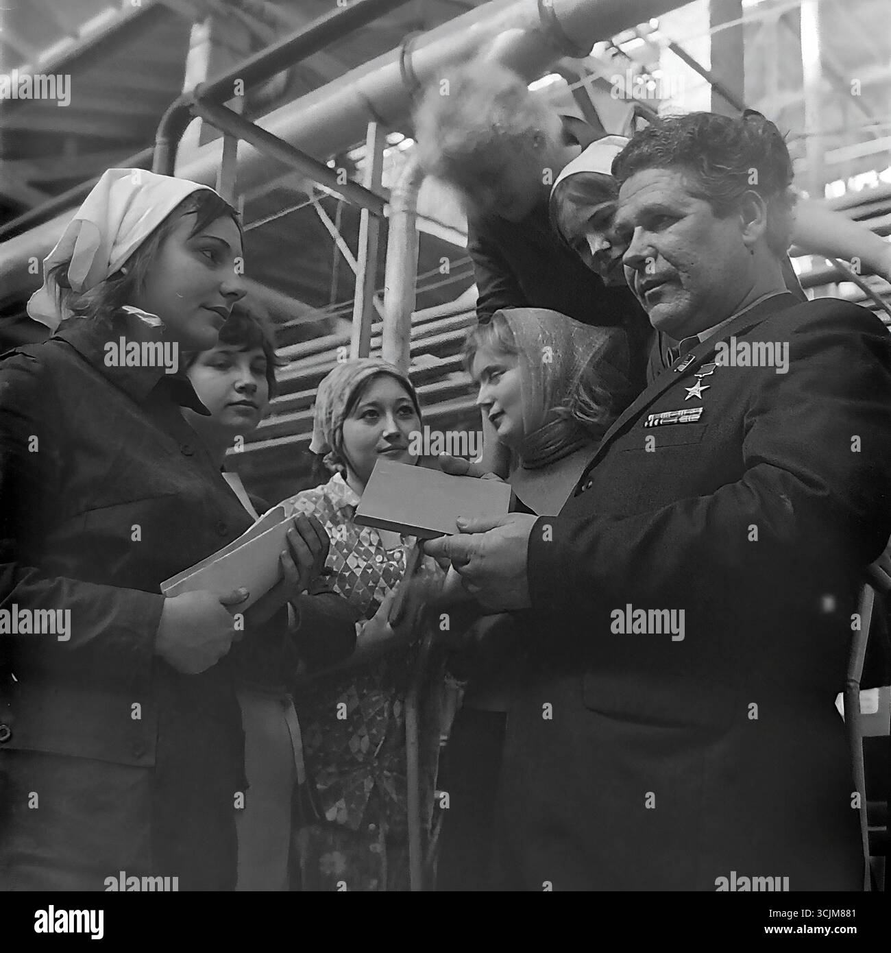 Ein Treffen eines Helden der Sozialistischen Arbeit mit einer Brigade junger Arbeiterinnen in einer Fabrik in Slawjansk, 1976. Diese Archivreportage, die eine Szene der Mentorschaft während der Stagnation-Ära aufzeichnet, ist ein Symbol für Generationenkontinuität, den Transfer von Berufserfahrung und die kreative Kultur eines friedlichen Donbas Stockfoto