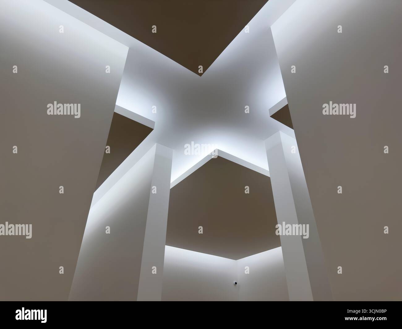 Futuristisches Deckendesign mit sich kreuzenden geometrischen Paneelen und sanfter, diffuser Beleuchtung. Minimalistisches architektonisches Detail, das einen abstrakten Stern bildet Stockfoto