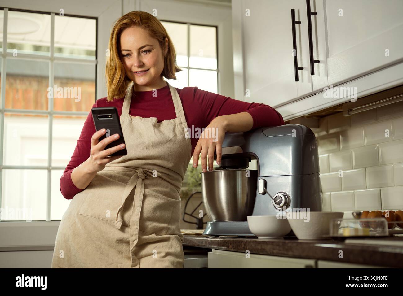 Millennials-Frau, die online Rezept sucht, zu Hause kocht Stockfoto