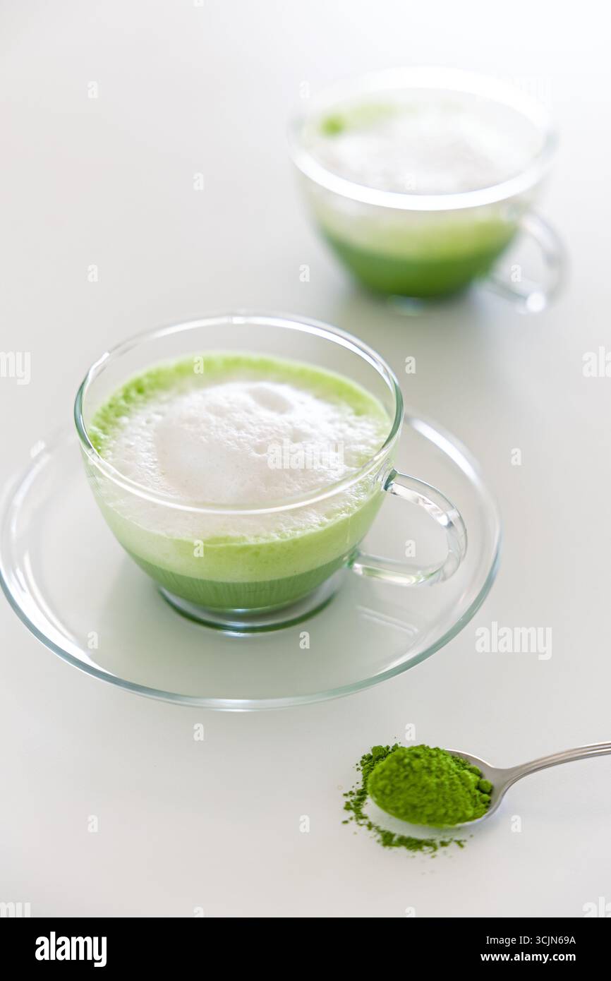 Eine hausgemachte zeremonielle Matcha-Latte in einer Glasschale, garniert mit cremigem Schaum, zubereitet mit hochwertigem japanischem Grünteepulver. Stockfoto