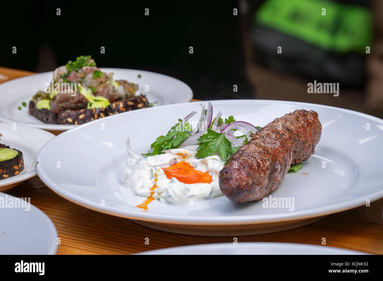Traditionelles hausgemachtes Lammkafta oder Kofta-Kebab mit Sauce und Joghurt. Traditionelle arabische und türkische Küche. Halal-Essen. Stockfoto