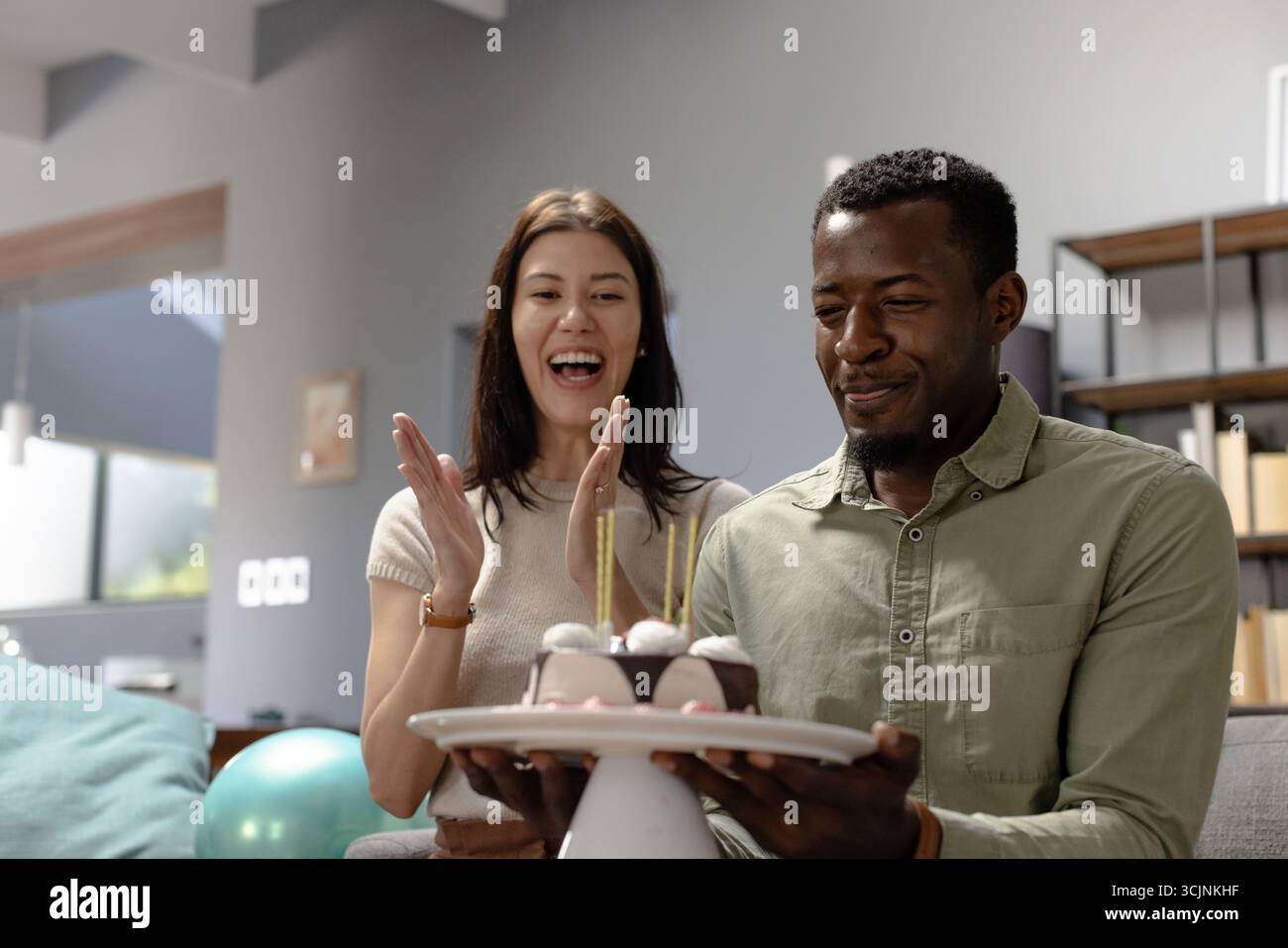 Wir feiern Geburtstag, glückliches Paar genießt Kuchen mit Kerzen zu Hause Stockfoto