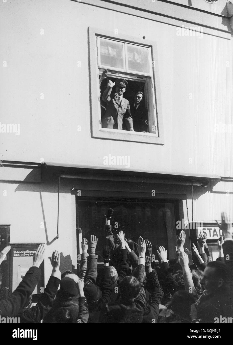 Adolf Hitler spricht die versammelte Menge von einem Fenster aus an. 1938 Stockfoto
