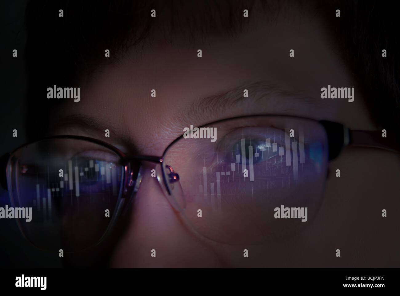 Nahaufnahme von Einzelpersonen, die sich auf Marktdaten für Kryptowährungen konzentrieren, die in einer dunklen Umgebung in einer Brille reflektiert werden, wobei Analyse und Aufmerksamkeit betont werden. Stockfoto