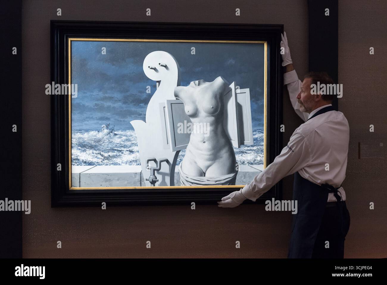 LONDON, VEREINIGTES KÖNIGREICH - 8. SEPTEMBER 2025: Ein Kunsthändler hält „La Statue volante“ von Rene Magritte, Schätzung: £ 9.000.000 - 12.000.000 während eines Fotoanrufs in Sotheby's Auktionshaus für die Ausstellung „Pauline Karpidas: The London Collection“ und Verkauf in London, Vereinigtes Königreich am 8. September 2025. Die außergewöhnliche persönliche Sammlung der legendären Mäzene und Ästhetik Pauline Karpidas, in der Meisterwerke surrealistischer Kunst und Möbeldesign zu sehen sind, die ihr einzigartiges Zuhause in London schmückten, wird am 17. Und 18. September im Sotheby's angeboten, zusammen auf über 60 Millionen Pfund geschätzt Stockfoto