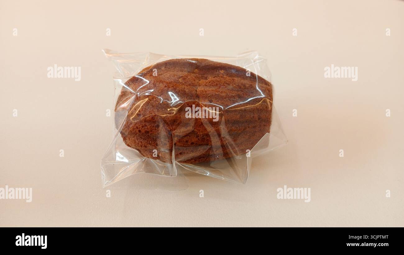 Madeleine-Kekse in durchsichtiger Kunststoffverpackung auf weißem Hintergrund Stockfoto