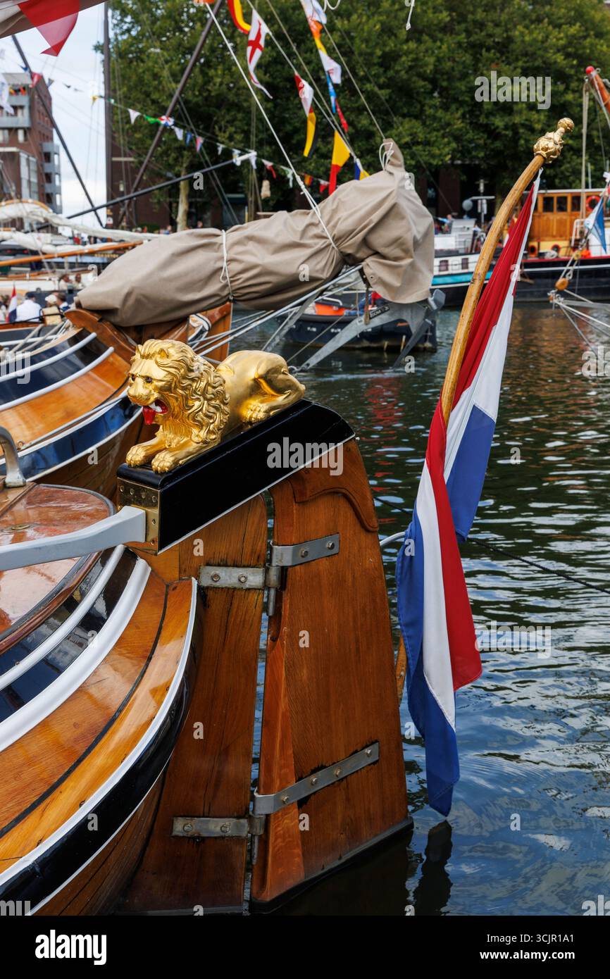 goldener Löwe auf einem Ruderblatt eines hölzernen Segelbootes, der während Sail Amsterdam, 21. August 2025, Niederlande, im Hafen von Ij vertäut war. Die Segel Amsterda Stockfoto